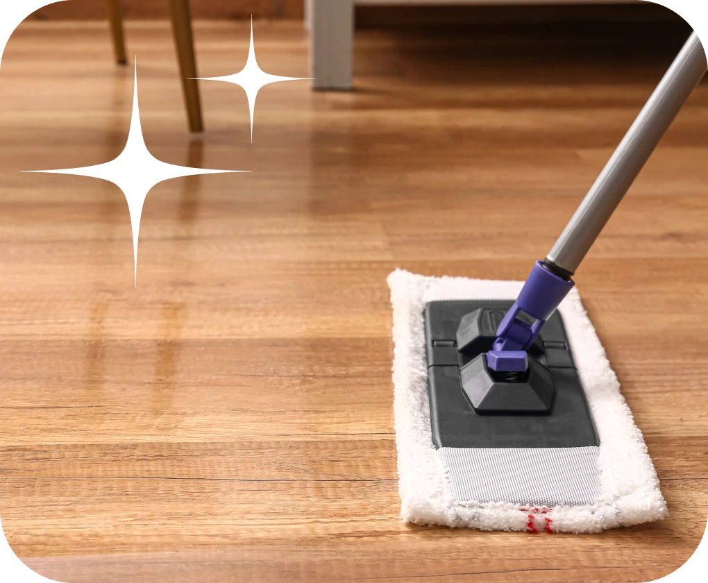 Microfiber mop sweeping hardwood floor close-up | Lloyd's Carpets & Draperies