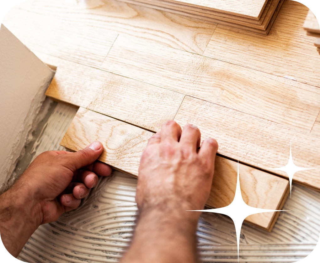 Worker installting glue-down stlye hardwood flooring | Lloyd's Carpets & Draperies