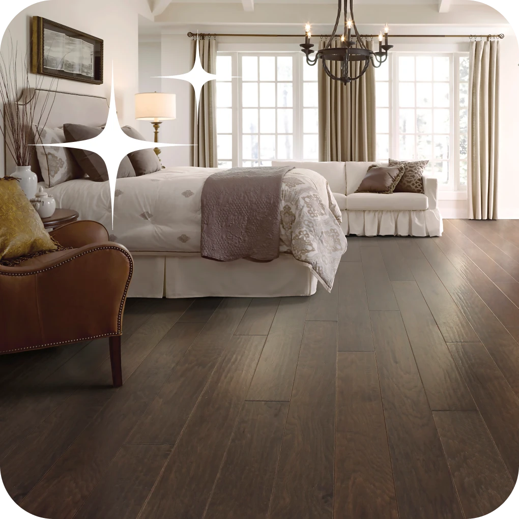 Dark hardwood flooring in contemporary bedroom with big bed | Lloyd's Carpets & Draperies