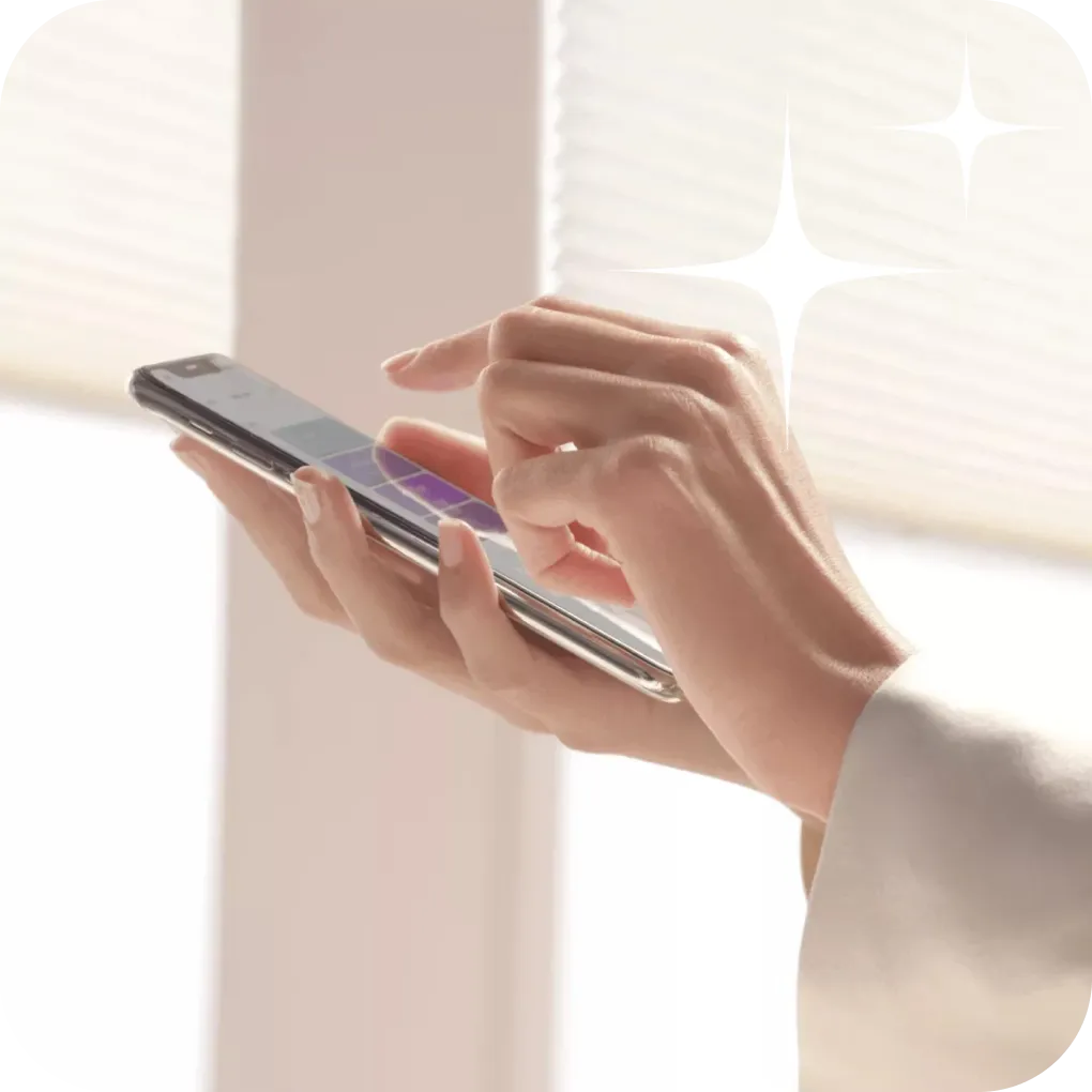 Woman controlling motorized windows with cellphone app | Lloyd's Carpets & Draperies
