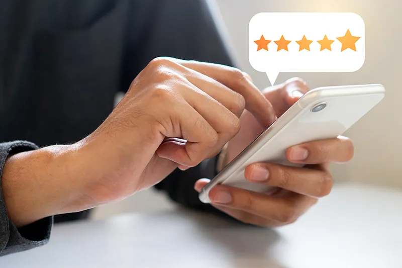 Person leaving a review on a cell phone closeup | Lloyd's Carpets & Draperies