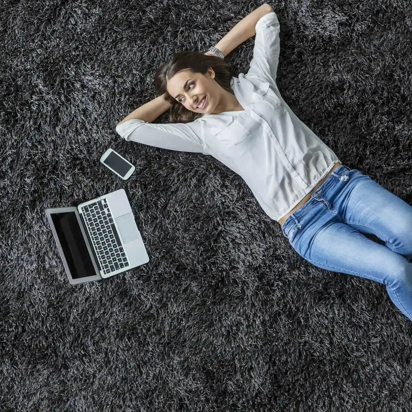 Happy lady laying on soft black carpet